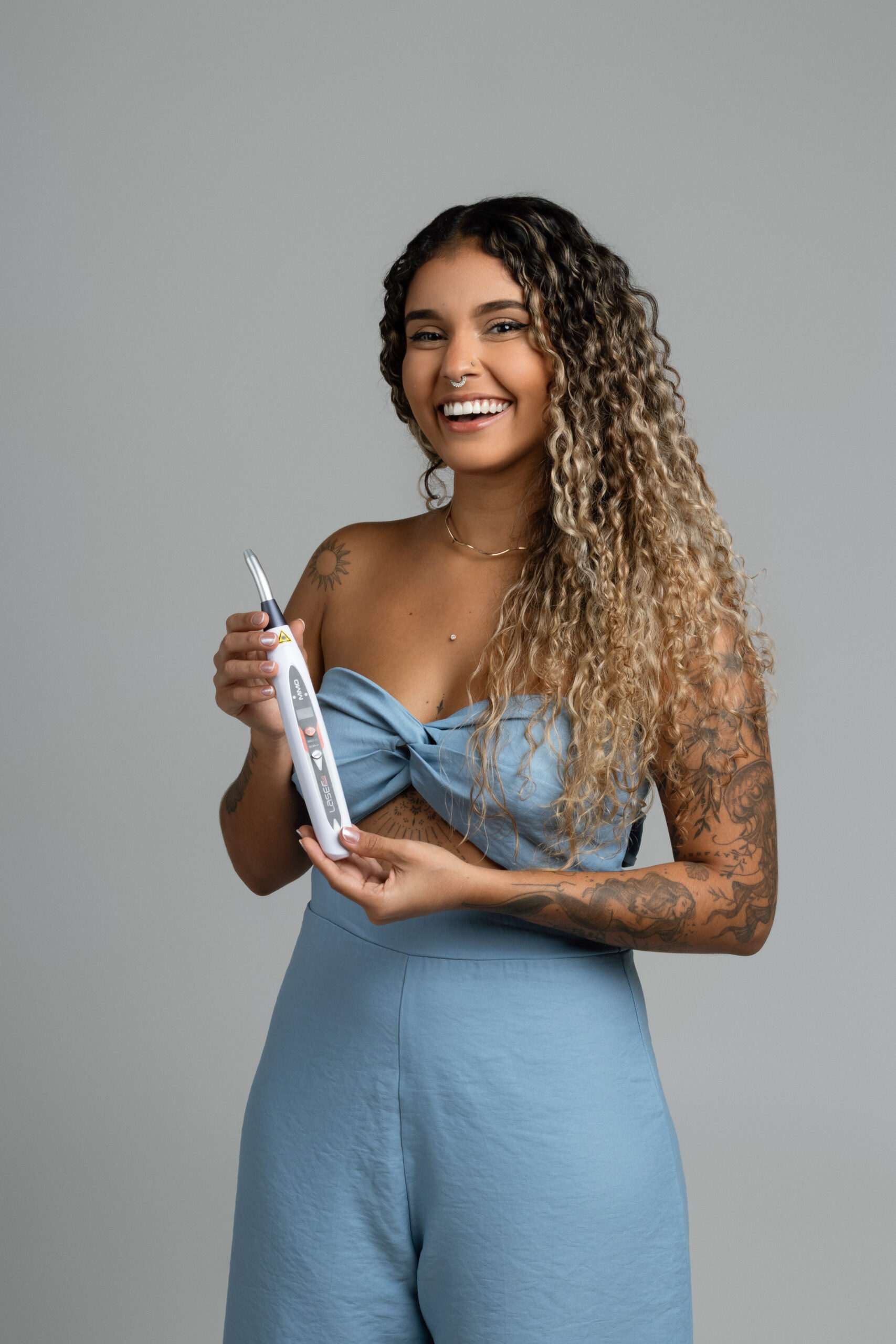 Maria do Piercing segurando o aparelho de laserterapia